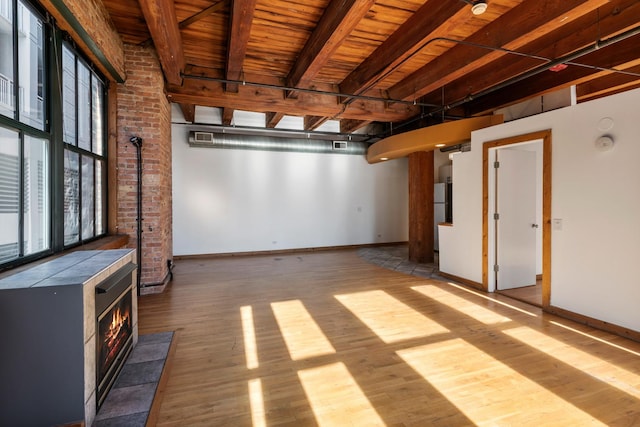 basement with a wood stove, wooden ceiling, and light wood-type flooring