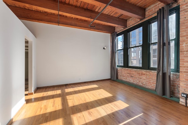 spare room with brick wall, beam ceiling, light hardwood / wood-style flooring, and wooden ceiling