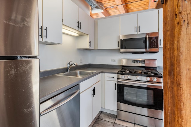 kitchen featuring light tile patterned flooring, appliances with stainless steel finishes, sink, and white cabinets