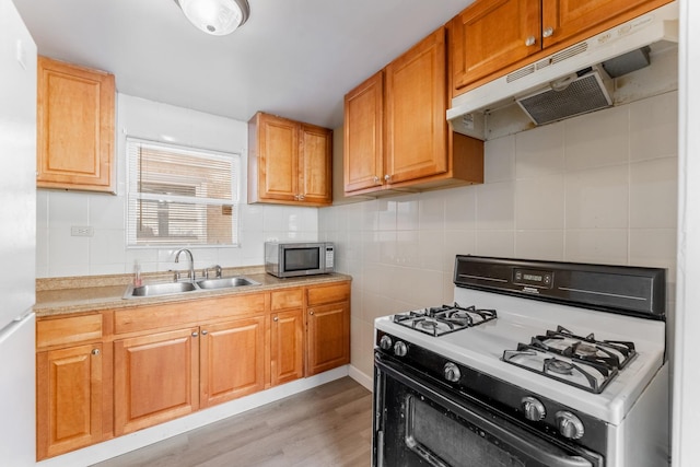 kitchen with white range with gas stovetop, sink, and light hardwood / wood-style floors