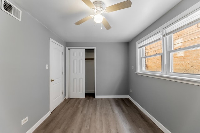 unfurnished bedroom with a closet, ceiling fan, and hardwood / wood-style flooring