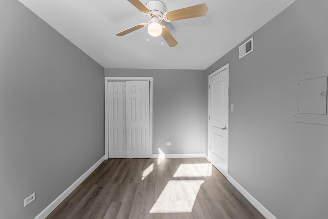 unfurnished bedroom featuring ceiling fan, dark wood-type flooring, and electric panel