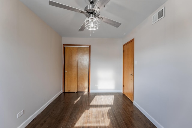 unfurnished bedroom with ceiling fan, dark hardwood / wood-style floors, and a closet