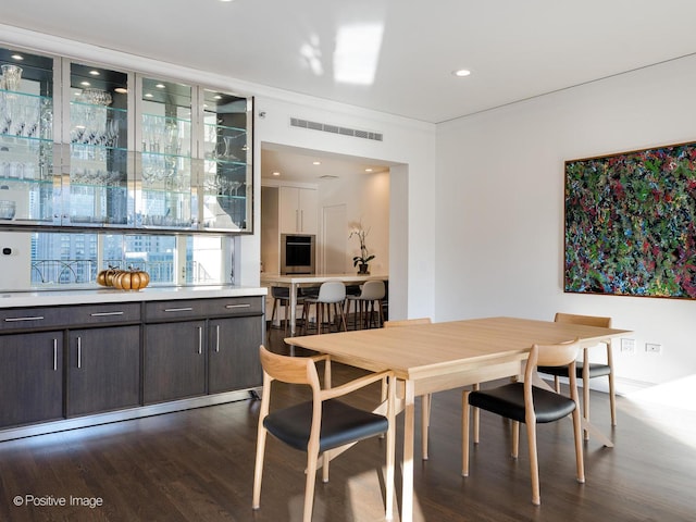 dining space with dark wood-type flooring and crown molding