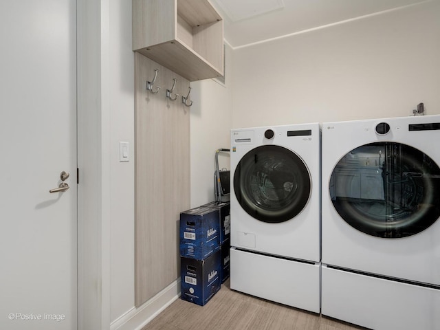 laundry room featuring separate washer and dryer and light hardwood / wood-style floors