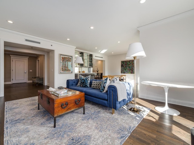 living room featuring dark hardwood / wood-style floors and crown molding