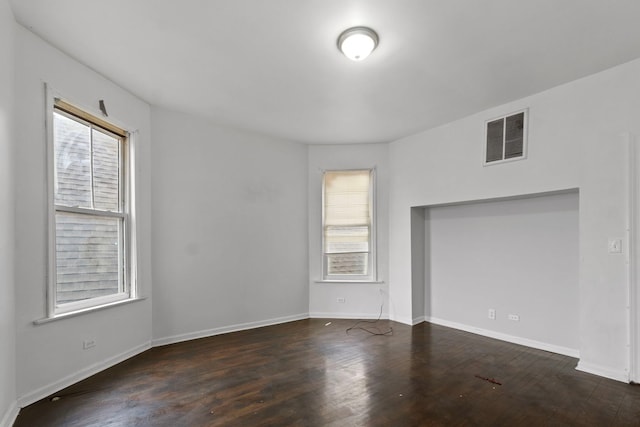 unfurnished room featuring dark wood-type flooring