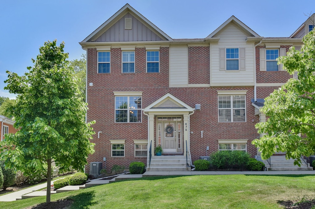 view of front facade with central AC and a front yard