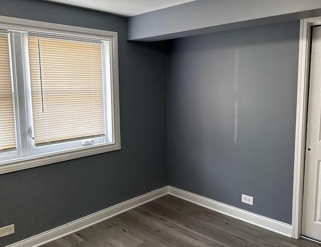 empty room featuring a wealth of natural light and dark hardwood / wood-style floors