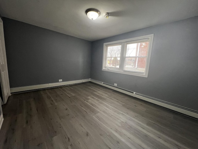 empty room featuring baseboard heating and wood-type flooring