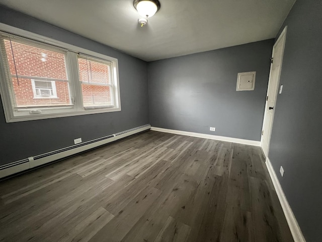 unfurnished room featuring hardwood / wood-style floors and a baseboard radiator