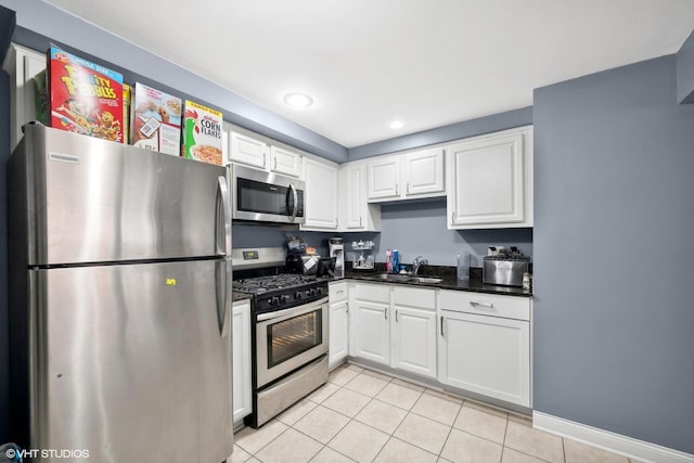 kitchen with white cabinets, appliances with stainless steel finishes, sink, and light tile patterned flooring