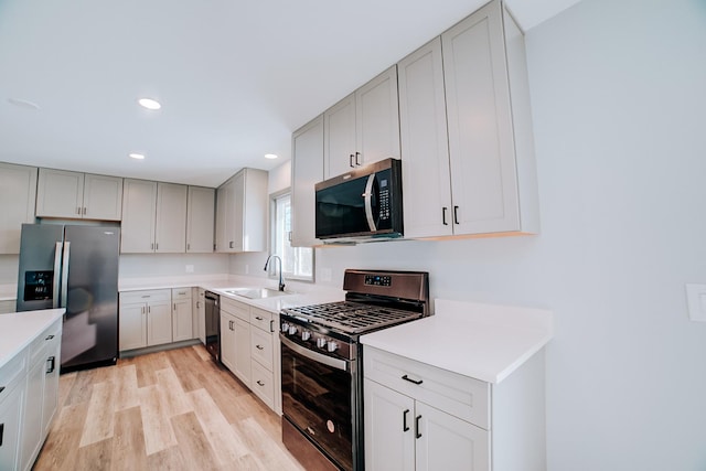 kitchen featuring sink, appliances with stainless steel finishes, and light wood-type flooring