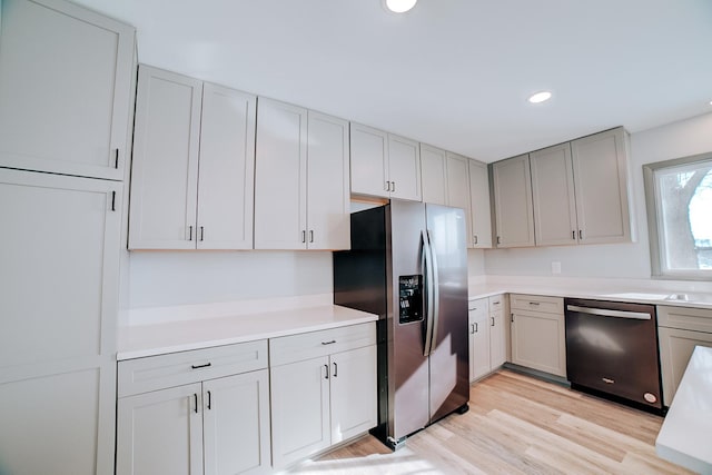 kitchen featuring stainless steel appliances, light hardwood / wood-style floors, and gray cabinets