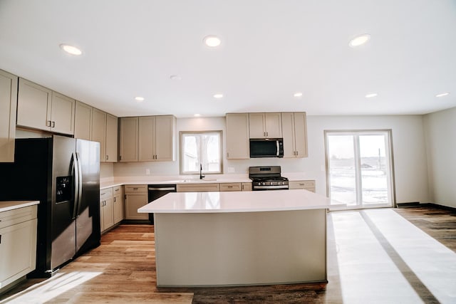 kitchen featuring a center island, appliances with stainless steel finishes, sink, and plenty of natural light