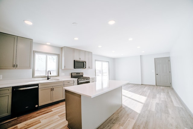 kitchen with light hardwood / wood-style flooring, sink, stainless steel appliances, and a kitchen island