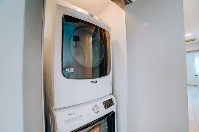 clothes washing area with stacked washer and dryer