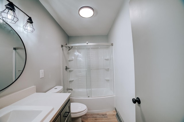 full bathroom featuring toilet, bath / shower combo with glass door, wood-type flooring, and vanity