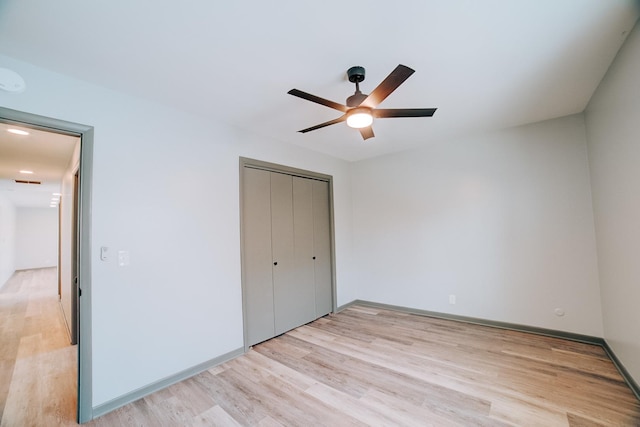 unfurnished bedroom with ceiling fan, a closet, and light hardwood / wood-style floors