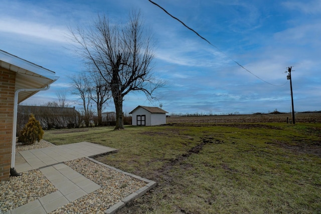 view of yard with a rural view and a shed