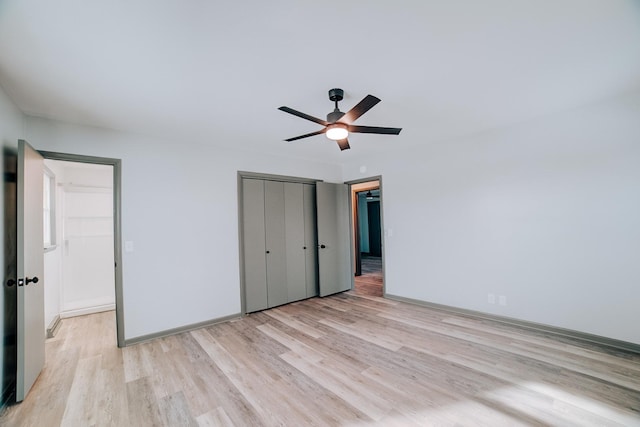 unfurnished bedroom with light wood-type flooring, ceiling fan, and a closet