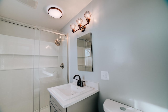 bathroom featuring toilet, vanity, and walk in shower