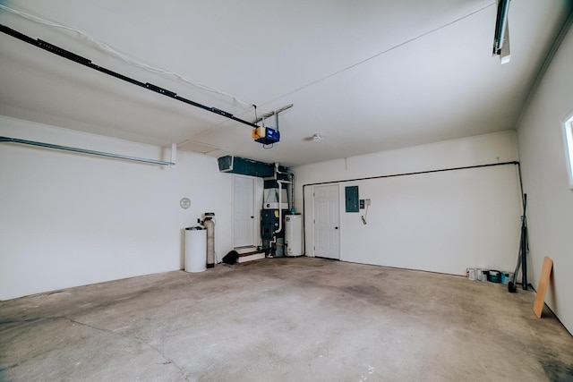 garage featuring electric panel, water heater, and a garage door opener