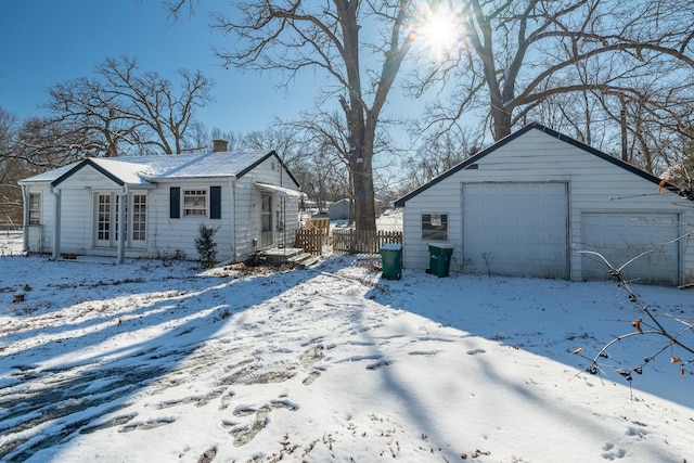 snow covered property with a garage