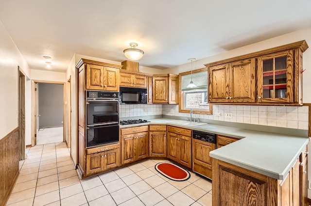 kitchen featuring sink, tasteful backsplash, black appliances, decorative light fixtures, and kitchen peninsula