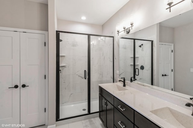 bathroom featuring a shower with shower door and vanity