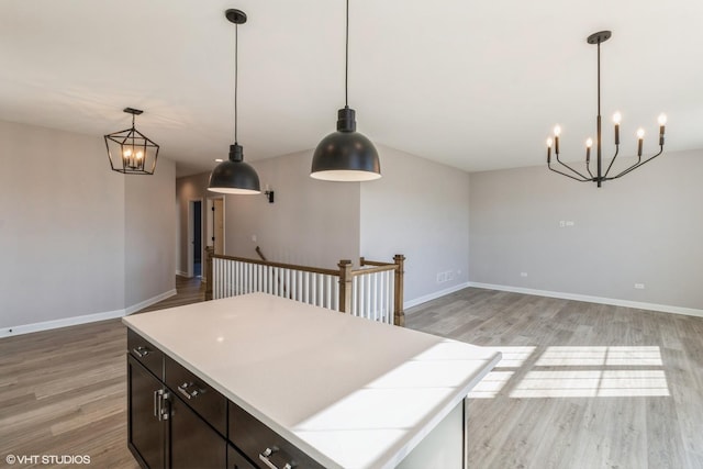 kitchen featuring light wood-type flooring, pendant lighting, a center island, and dark brown cabinetry