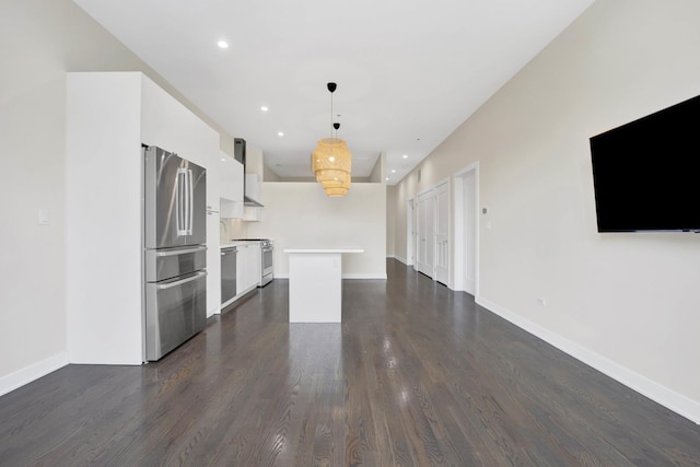 kitchen featuring appliances with stainless steel finishes, a kitchen island, white cabinetry, dark hardwood / wood-style flooring, and hanging light fixtures