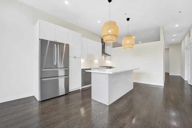 kitchen with a kitchen island, hanging light fixtures, stainless steel appliances, white cabinets, and dark hardwood / wood-style flooring