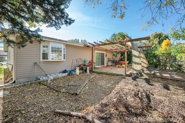 rear view of property with a wooden deck and a pergola