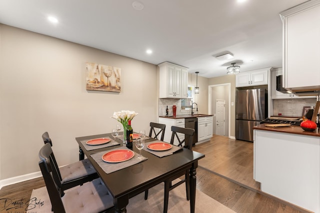 dining room with dark hardwood / wood-style floors and sink