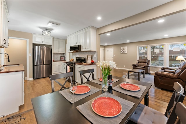 dining area with light wood-type flooring and sink