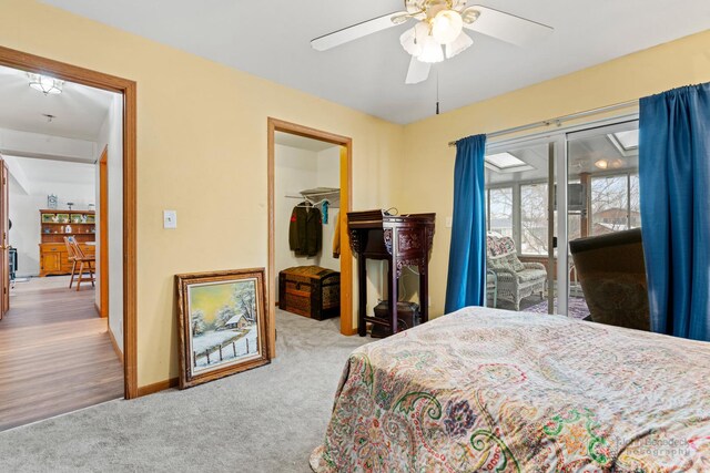 bedroom with a spacious closet, light carpet, a closet, access to outside, and ceiling fan