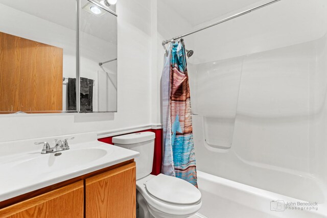 full bathroom featuring shower / bath combo with shower curtain, toilet, and vanity