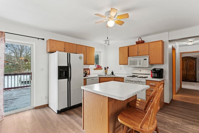 kitchen featuring sink, ceiling fan, white appliances, and light hardwood / wood-style floors