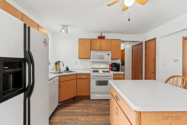 kitchen featuring ceiling fan, sink, dark wood-type flooring, white appliances, and a kitchen island