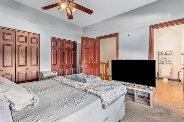 bedroom featuring multiple closets, ensuite bathroom, high vaulted ceiling, ceiling fan, and light tile patterned flooring