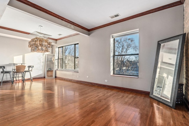 interior space with a chandelier, ornamental molding, and hardwood / wood-style floors