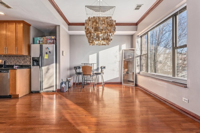 kitchen with ornamental molding, hardwood / wood-style floors, and stainless steel appliances