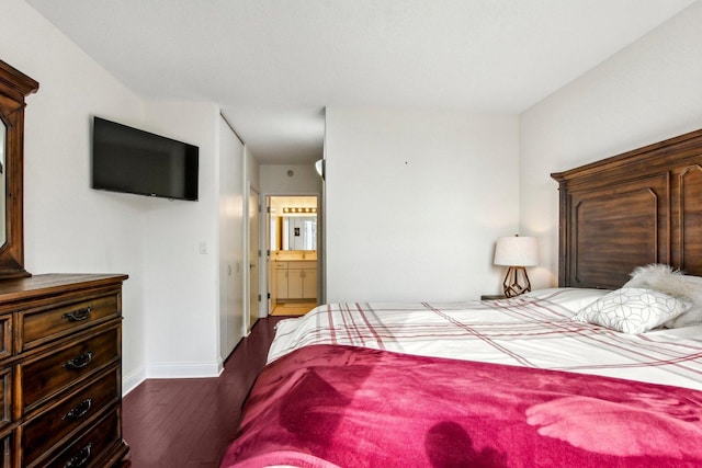 bedroom featuring ensuite bathroom and dark hardwood / wood-style floors