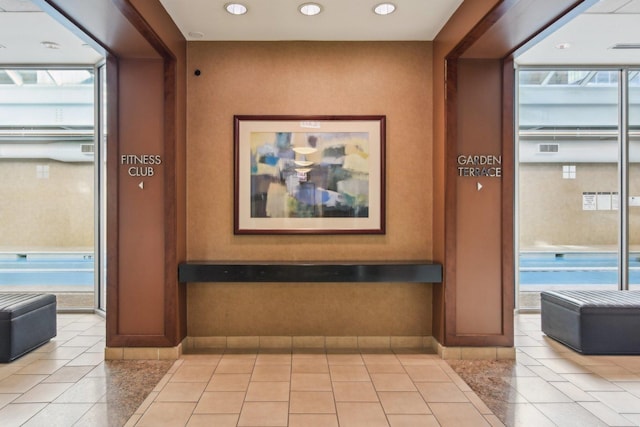 hallway with expansive windows and light tile patterned floors