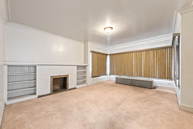 unfurnished living room with radiator heating unit, carpet floors, ornamental molding, a brick fireplace, and built in shelves