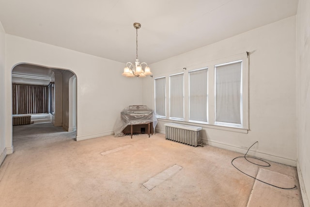 unfurnished dining area with radiator, carpet, and a notable chandelier