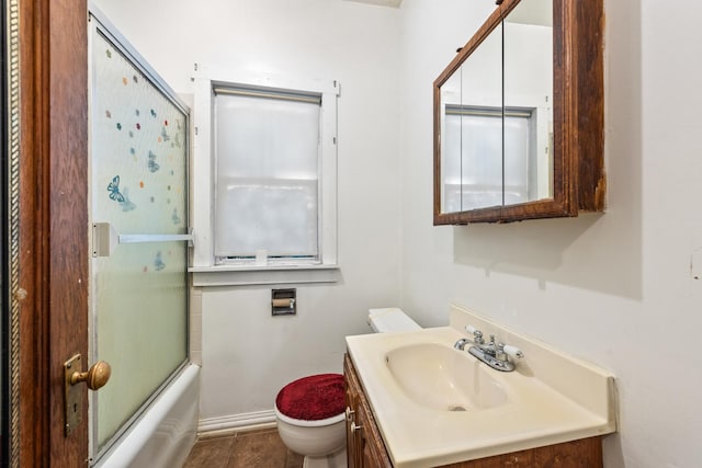 full bathroom featuring tile patterned flooring, vanity, shower / bath combination with glass door, and toilet