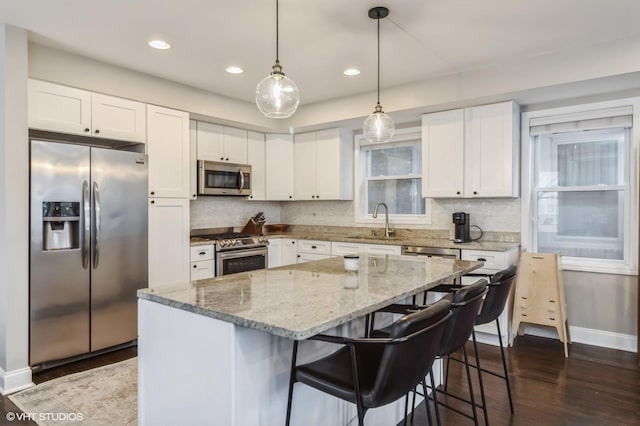 kitchen with white cabinets, a center island, dark hardwood / wood-style flooring, stainless steel appliances, and sink