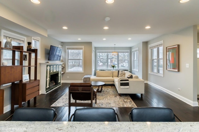 living room with dark wood-type flooring and a brick fireplace